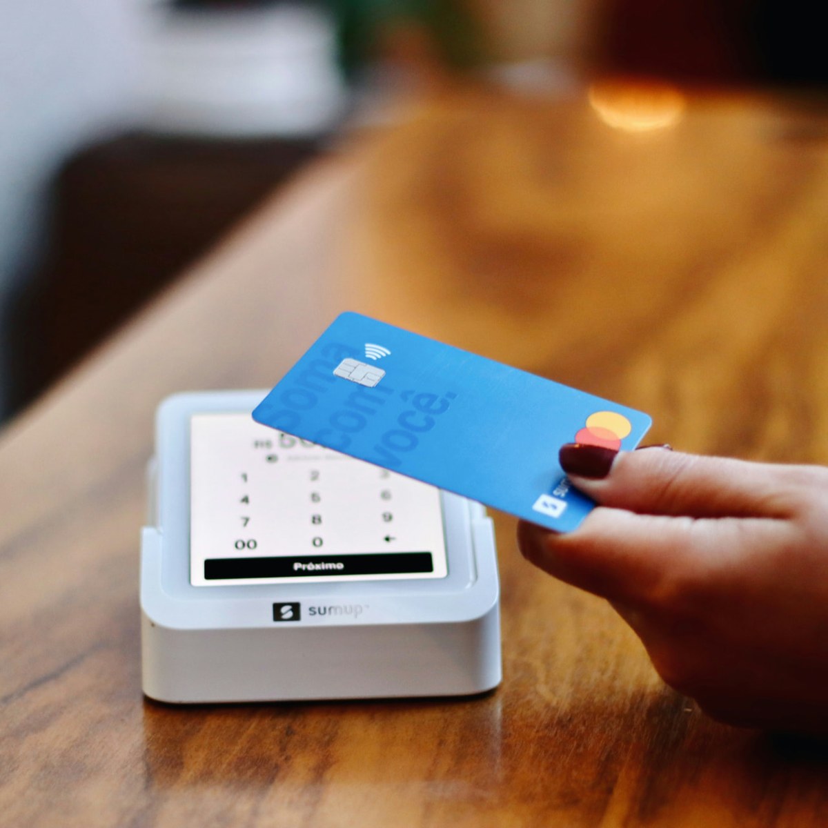 A customer tapping a card on a small business card reader